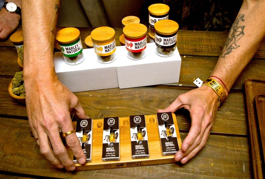 Sales Rep for Marley Natural lays out oils and vials of marijuana. Photo Credit: Steve Appleford