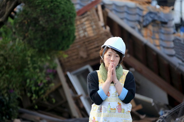 Woman in shock after homes were destroyed during the April 16, 2016 earthquake in southern Japan. Photo Credit: KYODO KYODO / REUTERS