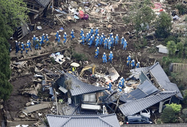 Rescue workers conduct a search and rescue operation to a collapsed house at a landslide site caused by earthquakes in Minamiaso town, Kumamoto prefecture, southern Japan, in this photo taken by Kyodo April 16, 2016. Mandatory credit REUTERS/Kyodo ATTENTION EDITORS - FOR EDITORIAL USE ONLY. NOT FOR SALE FOR MARKETING OR ADVERTISING CAMPAIGNS. THIS IMAGE HAS BEEN SUPPLIED BY A THIRD PARTY. IT IS DISTRIBUTED, EXACTLY AS RECEIVED BY REUTERS, AS A SERVICE TO CLIENTS. MANDATORY CREDIT. JAPAN OUT. NO COMMERCIAL OR EDITORIAL SALES IN JAPAN.
