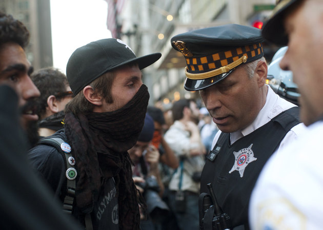 A protester faces off with a Chicago police officer during an anti-NATO protest march in Chicago May 19, 2012. Hundreds of demonstrators protested peacefully on Saturday on the eve of the NATO summit in Chicago, gathering outside Mayor Rahm Emanuel's home to criticize cuts in mental health services before moving downtown under the close eye of police. REUTERS/Andrew Kelly (UNITED STATES - Tags: POLITICS MILITARY CIVIL UNREST)